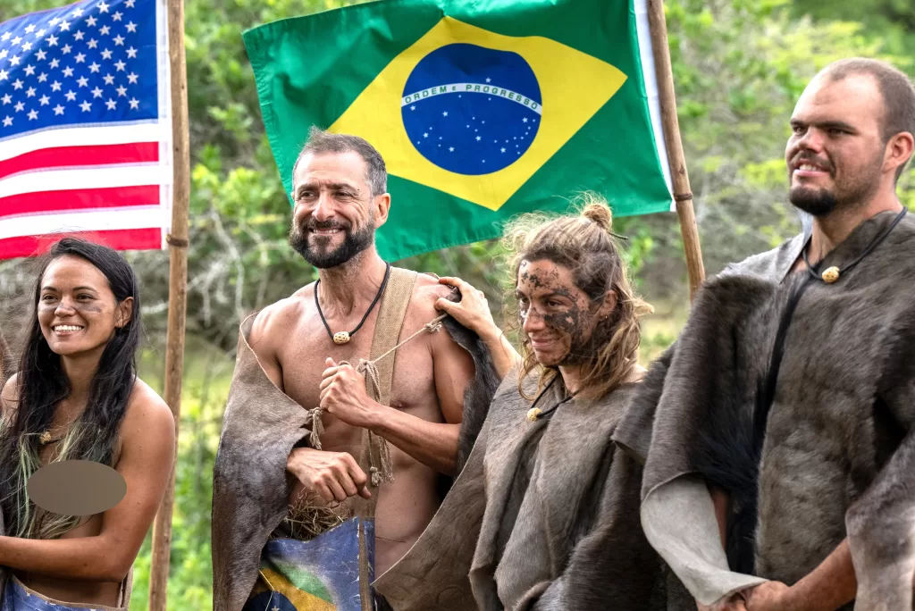 Rene Murad e Marina Fukushima em frente a bandeira do Brasil em Largados e Pelados Campeoes do Mundo
