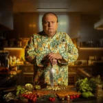 Erick Jacquin posando com faca em tábua na arte oficial da 5a temporada de Pesadelo na Cozinha